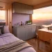 Wide landscape view of a serene van life interior with lavender bedding and moody grey cabinetry at sunset.