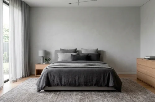 Sophisticated grey bedroom with layered textures, charcoal linens, and natural light in a 2:1 wide shot.
