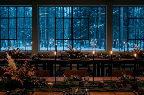 Sophisticated Scandi-Noir wedding reception with black candles and winter forest views.