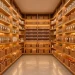 A wide, high-end organized kitchen pantry featuring wooden shelves and uniform glass storage containers.