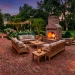 A luxurious wide landscape of a traditional brick backyard patio with warm evening lighting.