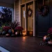 Dramatic modern porch decorated with various matte black pumpkins and moody fall foliage at twilight.