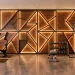Wide shot of a luxury home gym featuring a large geometric accent wall and high-end fitness equipment.