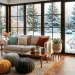 Cozy winter sunroom featuring chunky knitted blankets, pillows, and snowy garden views through windows.