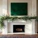 Sophisticated St. Patrick's Day mantel with eucalyptus garland and brass candlesticks in a bright room.