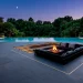 Luxurious modern slate patio with dark charcoal slabs and sunken fire pit area at twilight.