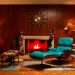 Vintage mid-century living room with silver Christmas tree and teal Eames lounge chair.