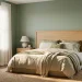 A serene sage green bedroom with linen bedding, oak furniture, and natural sunlight for a peaceful vibe.