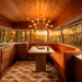 Luxurious mid-century modern camper van interior with walnut wood and retro orange decor at sunset.
