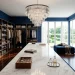 Sophisticated navy blue walk-in closet with marble island and crystal chandelier luxury interior.