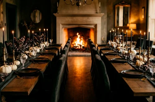 Sophisticated Halloween dining room with black candles, white pumpkins, and gold table settings.