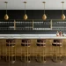 A luxurious home bar featuring white marble countertops and brushed brass accents in a modern setting.