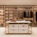 A luxurious dream dressing room featuring a marble island, custom lighting, and organized designer clothing.