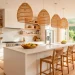 Wide panoramic shot of a sunny modern kitchen with honey-hued rattan pendants and woven accents.
