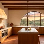 Wide horizontal banner of a modern Mediterranean kitchen with warm plaster walls and sunset light.