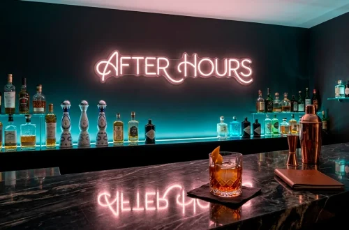 Luxury home bar with moody neon lighting and dark charcoal walls for a nightclub atmosphere.