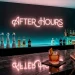 Luxury home bar with moody neon lighting and dark charcoal walls for a nightclub atmosphere.