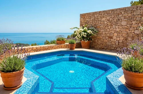 Wide Mediterranean patio featuring a vibrant blue tiled pond surrounded by terracotta pots and bougainvillea.