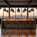Large professional industrial kitchen with brick walls, concrete island, and stainless steel range.
