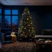 Modern living room featuring a midnight blue themed Christmas tree and moody holiday decor accents.