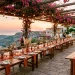 Wide shot of a sun-drenched Mediterranean wedding reception with terracotta decor and sunset lighting.