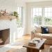 Beautiful modern living room fireplace mantle decorated for summer with sun-bleached driftwood and coastal greenery