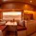 Cozy van life interior with terracotta velvet cushions and warm wood accents at sunset.