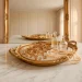 Wide landscape shot of an elegant marble vanity featuring a large vintage mirror tray with jewelry and sunlight.