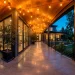 Modern industrial wrap-around porch featuring a smooth concrete floor, black steel railings, and warm cedar ceiling.