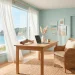 Bright and airy coastal home office with natural light, seaglass blue walls, and a white desk.