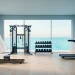 Luxury coastal home gym with mist blue walls and ocean views through large windows.