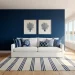 A sophisticated modern coastal living room featuring a navy accent wall, white linen sofa, and navy throw pillows.
