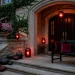 Sophisticated fall porch with dark burgundy and plum decor, glowing lanterns, and rich autumn textures.