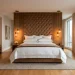 Luxurious five star hotel inspired master bedroom suite with elegant plush bedding and warm symmetrical lighting