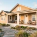 A modern coastal home featuring textured sandy neutral vinyl siding and crisp white architectural trim.