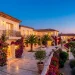Luxurious Mediterranean villa with multiple ornate wrought iron balconies and warm architectural lighting.