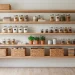 Small pantry organized with natural oak floating shelves and clear glass storage jars.