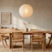 Serene Japandi style dining room featuring a light oak table, rattan chairs, and a washi paper pendant light
