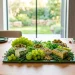A beautifully styled green charcuterie board with fresh grapes and herb cheeses on a modern dining table.