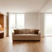 Modern multi-purpose home office and guest bedroom interior with sleeper sofa and wooden desk.