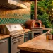Luxurious outdoor kitchen with a colorful Moroccan tile backsplash and stainless steel grill at sunset.