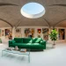 Wide panoramic view of a modern eclectic attic interior featuring exposed wood beams and colorful decor.