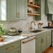 Beautifully painted soft sage green kitchen cabinets with brass hardware in a modern rental home.
