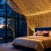 Wide panoramic shot of a magical bedroom with a sprawling golden fairy light canopy over a large bed.