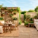Cozy small patio featuring soft beige and cream decor with sunlight expanding the space visually.