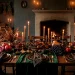 Moody dark cottagecore Thanksgiving table with forest green velvet and antique brass candlesticks in a cozy room.