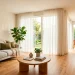 Wide panorama of a bright, functional small living room layout with modern furniture and natural light.
