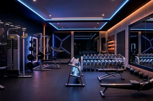 Luxury modern home gym featuring sleek stainless steel equipment and moody cinematic lighting