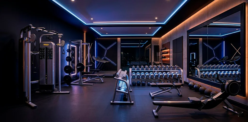 Luxury modern home gym featuring sleek stainless steel equipment and moody cinematic lighting