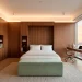 Wide 2:1 banner showing a modern small bedroom with walnut multi-functional furniture and sunset views.
